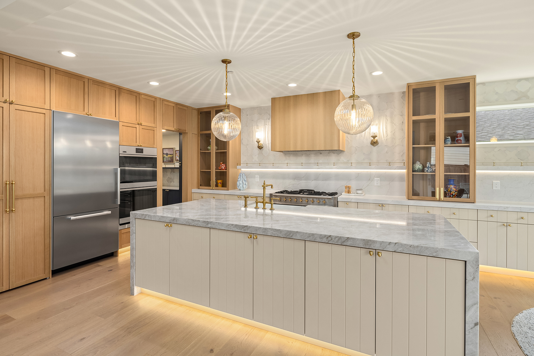 Brynn Dougherty in a renovated Edmonds kitchen with white oak cabinetry and brass fixtures
